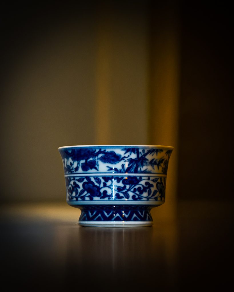Close-up of a beautifully crafted Chinese porcelain tea cup with intricate blue floral patterns, showcasing the fine craftsmanship and cultural heritage of traditional Chinese pottery.