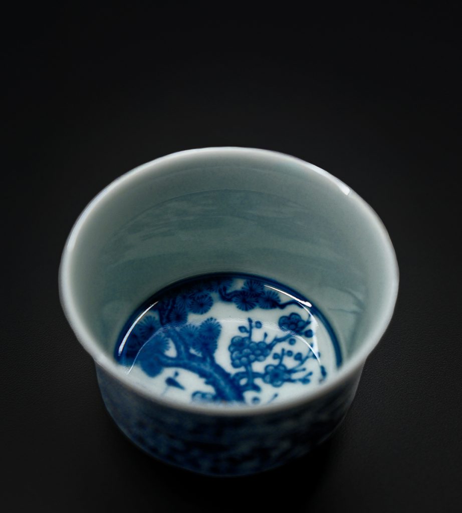 Close-up of a Chinese tea cup with delicate blue floral designs, highlighting the beauty and origin of Chinese tea culture.