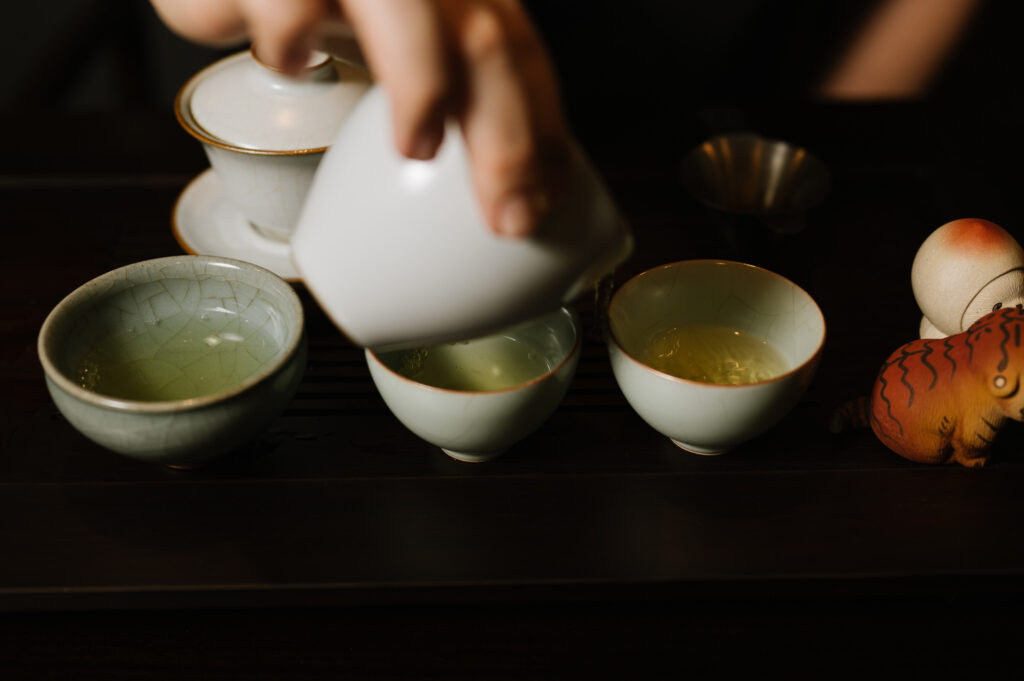 Chinese Tea in SG : A tea master pouring tea into clear teacup, reflecting meditation in motion.