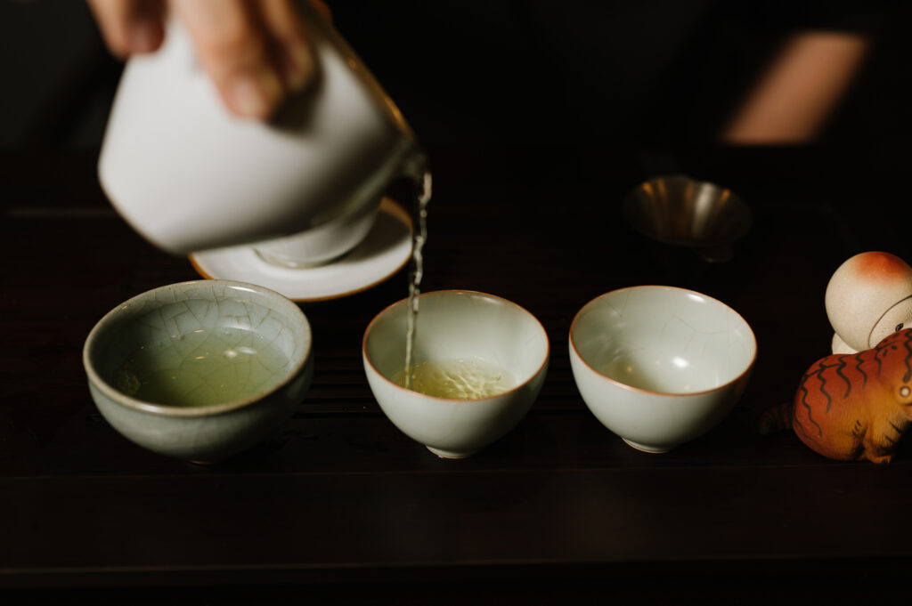 Luxury Chinese Tea : A traditional Chinese teapot pouring golden tea into a delicate cup, capturing stillness and grace.
