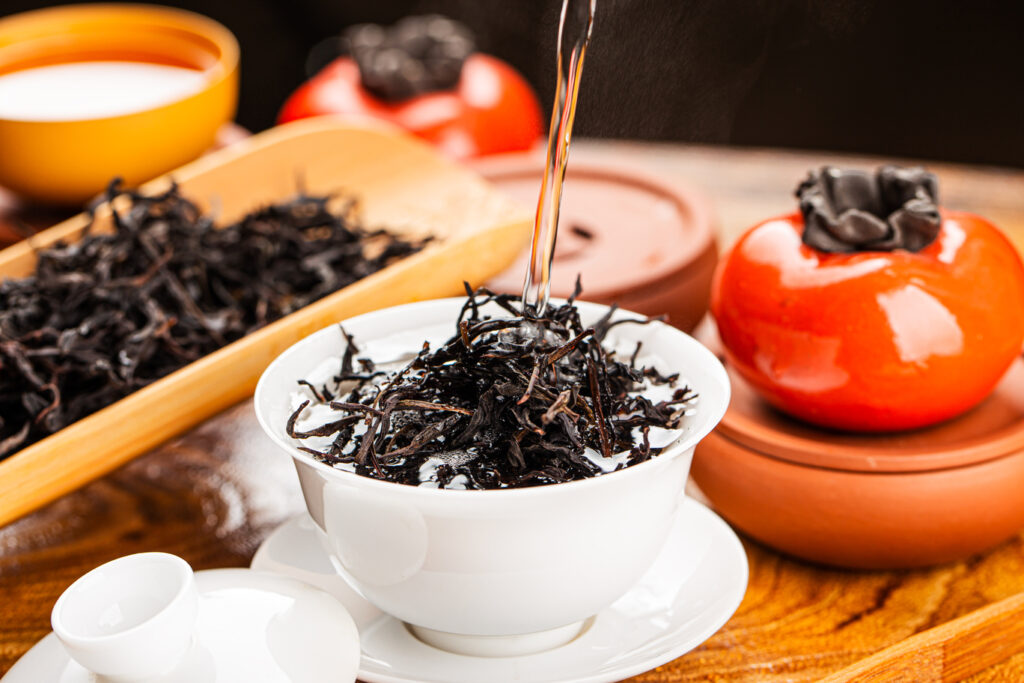 Tea Store in SG : An elegant teapot and porcelain cups set on a wooden table, capturing the art of premium tea preparation