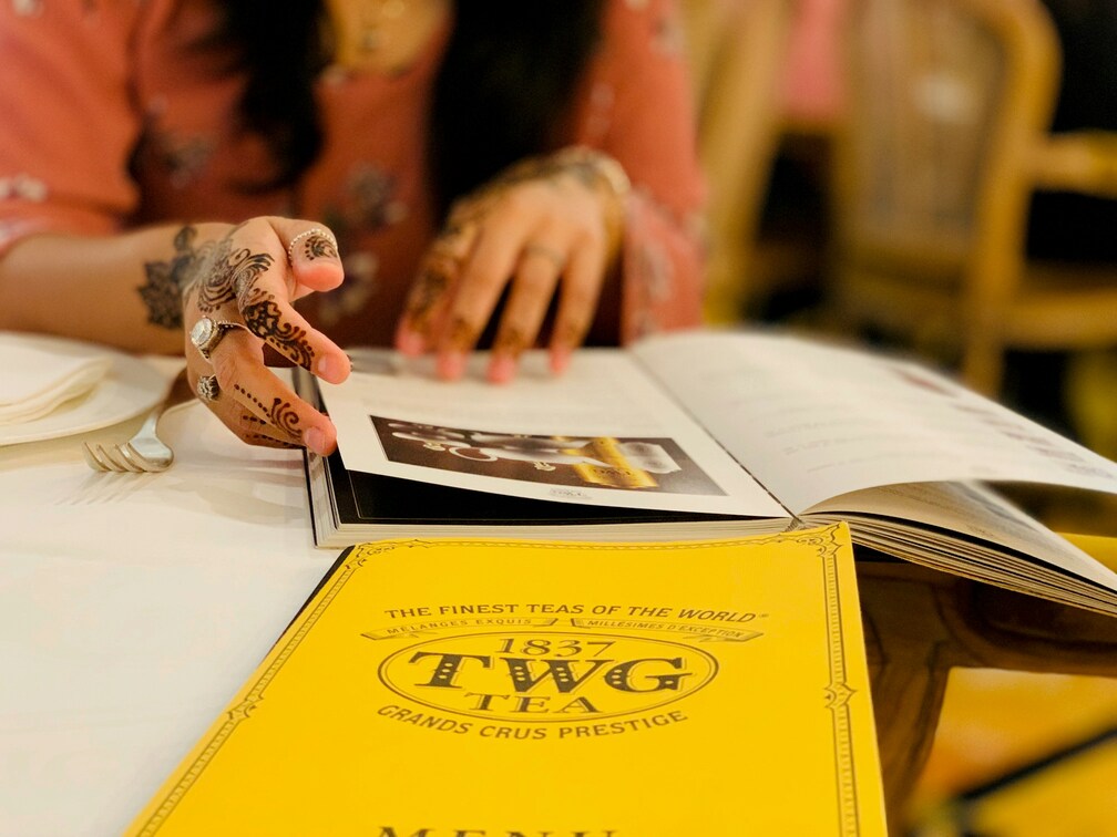 Tea Shop in SG : Elegant TWG Tea salon interior with gold accents and fine tea displays in Marina Bay Sands.