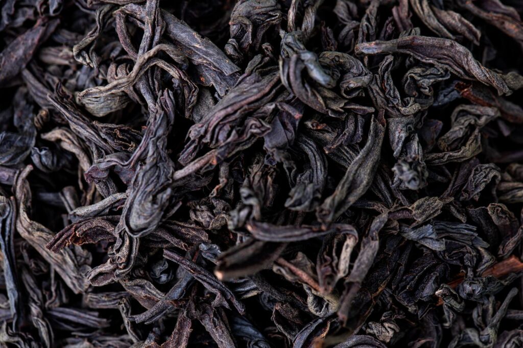 A close-up of loose black tea leaves, showcasing their rich texture and deep, earthy tones.