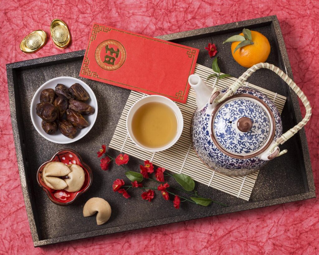 A meaningful moment from a Chinese wedding tea ceremony, where the couple serves tea to elders using ornate cups, symbolising respect, gratitude, and familial blessings