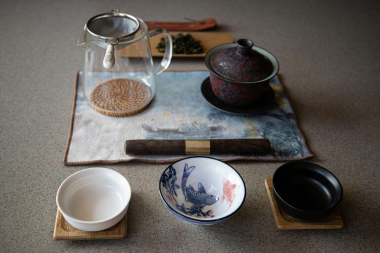 The image showcases a traditional Chinese tea ceremony setup, featuring a gaiwan, a fairness cup, and small tasting cups elegantly arranged on a wooden tea tray. This serene display highlights the art of tea preparation, embodying the cultural history and respect for purity associated with tea ceremonies.