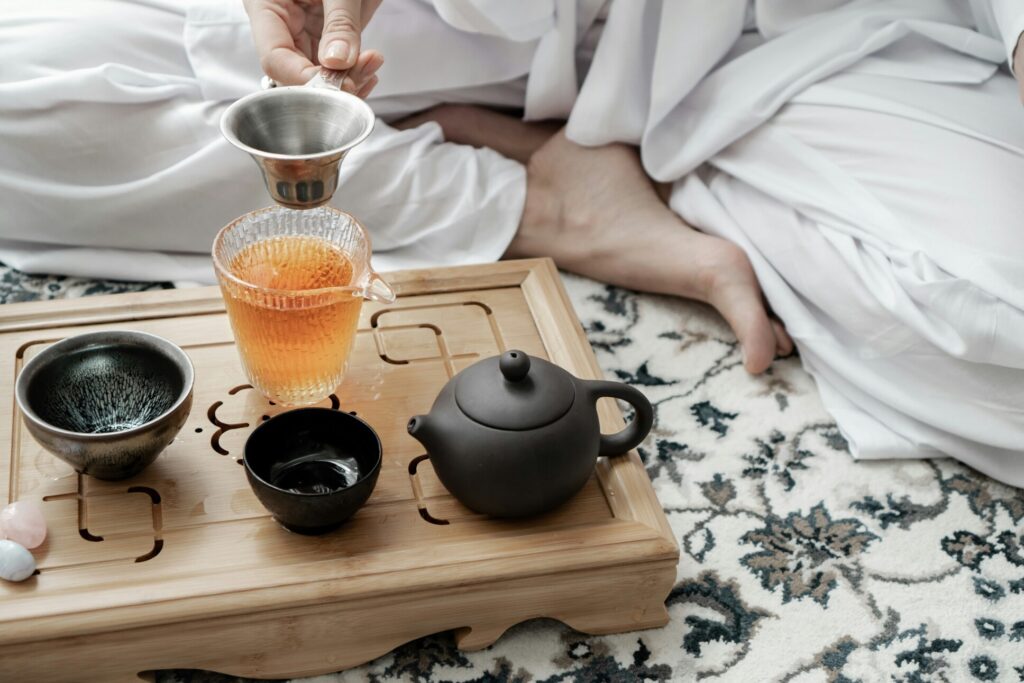 Green Tea : A skilled tea master gracefully pouring tea into a porcelain cup, embodying tradition and precision.