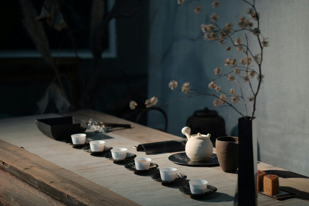 Green Tea : A serene tea table setup featuring a cup of green tea, dried leaves, and elegant ceramic ware.