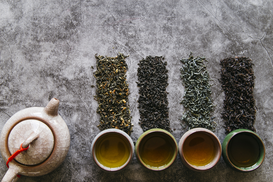 pu erh tea caffeine : An assortment of different tea varieties laid out on a table, showcasing diverse leaves and caffeine levels.