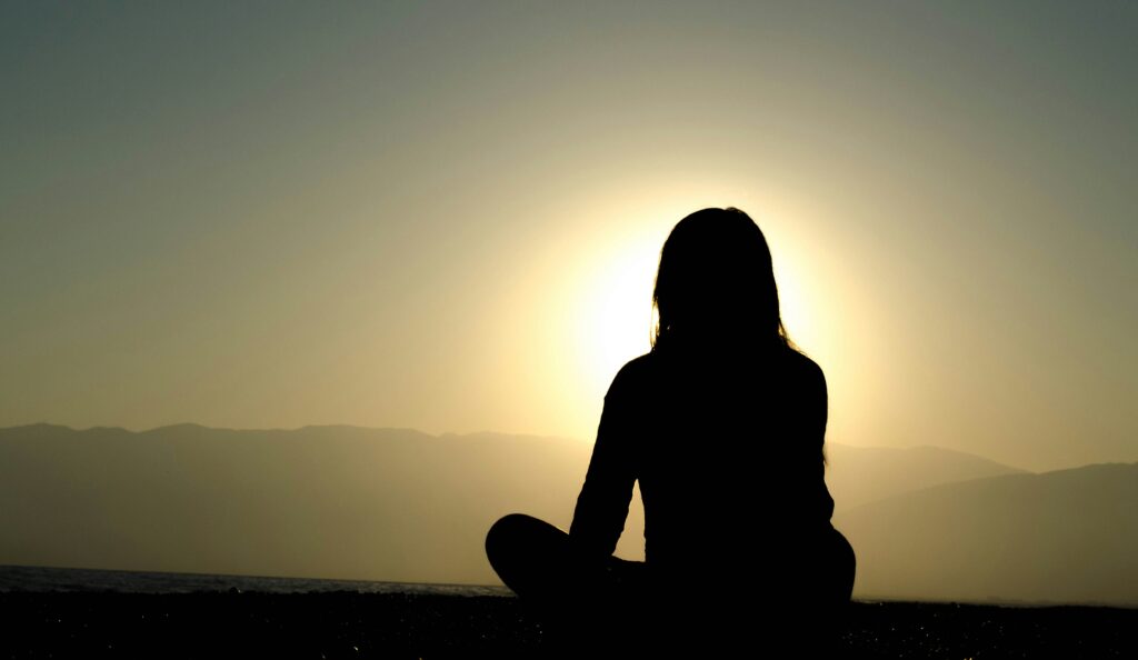 A woman sitting peacefully with a cup of Chinese tea, reflecting a moment of calm and the soothing benefits of traditional tea for stress relief.