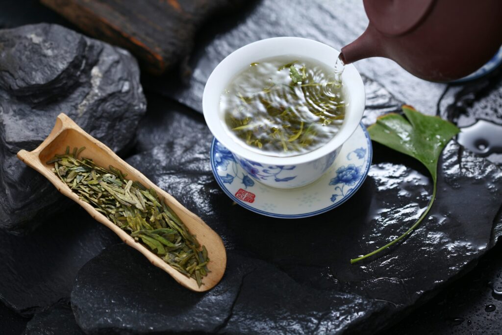 A steady pour of green tea into a cup, highlighting warmth, flow, and the art of tea serving.