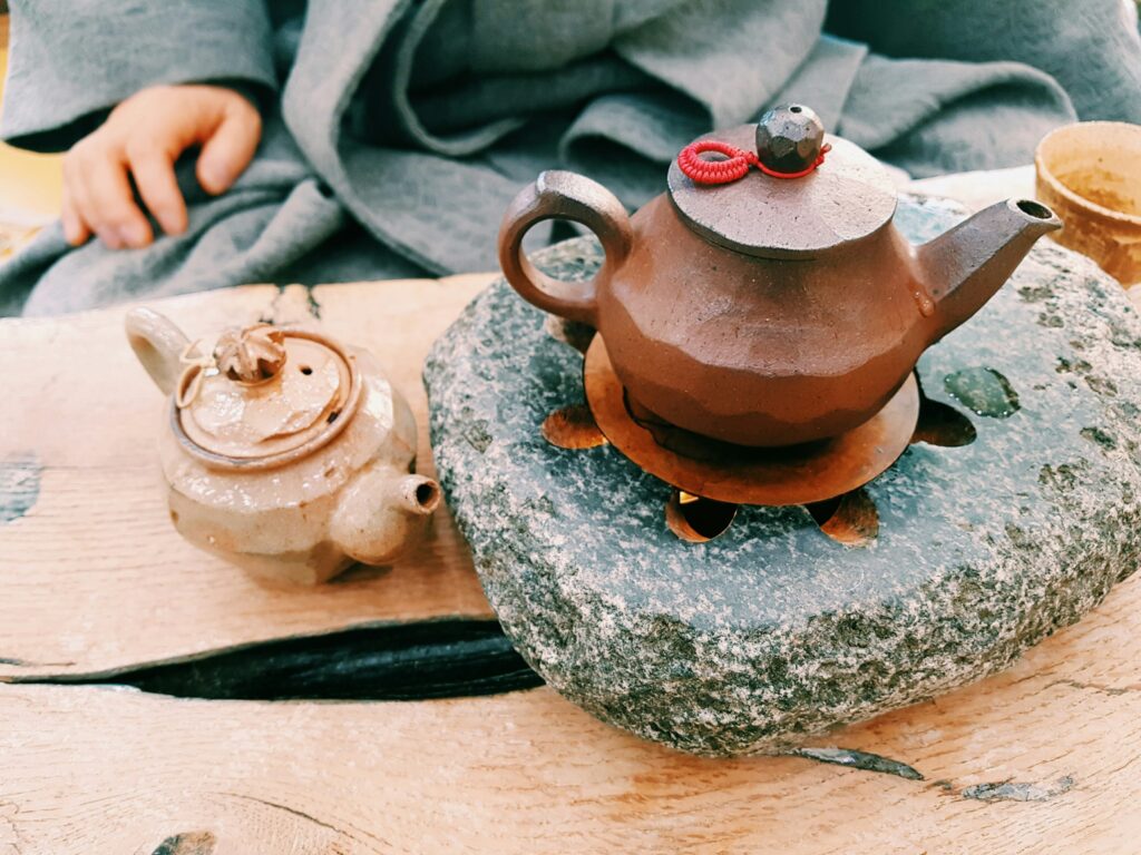 A traditional teapot resting on natural stone, symbolising harmony between nature and tea, and the quiet beauty of slow, intentional brewing.