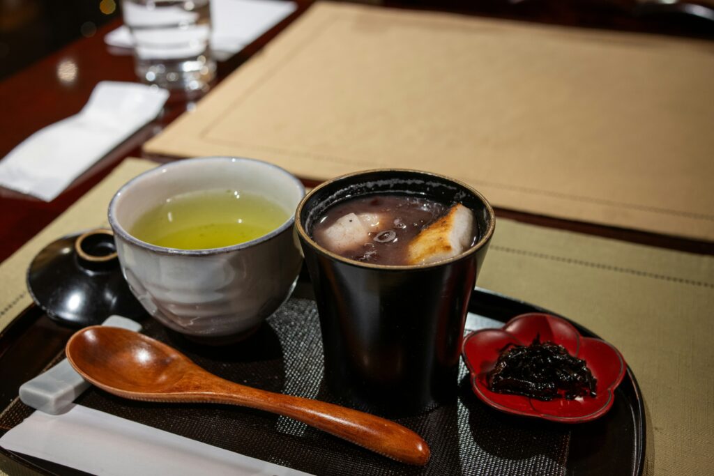 A warm cup of green tea served alongside a thoughtfully prepared meal, highlighting green tea as a refined and harmonious dining companion.