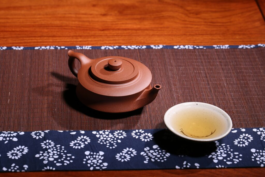 A Chinese tea cup placed gently on a wooden table, evoking stillness, simplicity, and an unhurried tea moment.