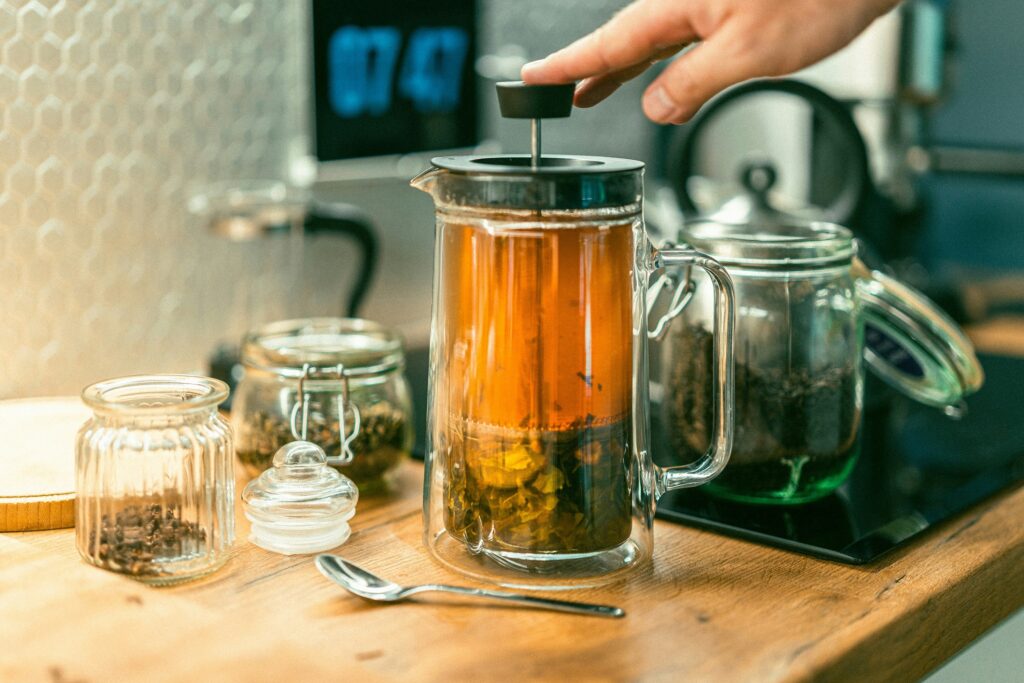 Hands carefully steeping and extracting tea leaves to release their natural aroma and flavour, showcasing the craftsmanship behind a perfect cup of tea.