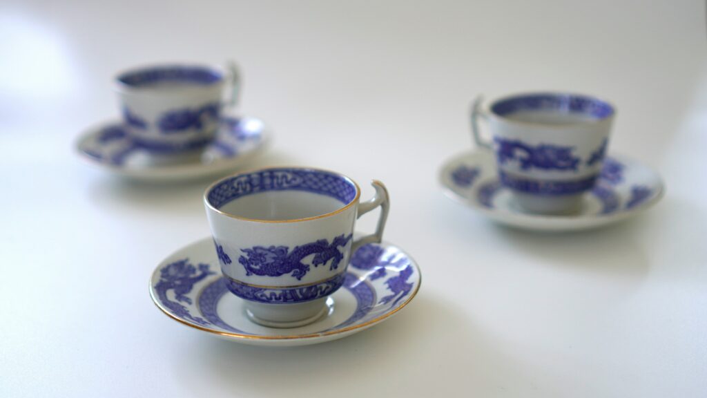 Single blue-and-white porcelain tea cup displayed in detail, featuring traditional motifs and fine hand-painted lines.