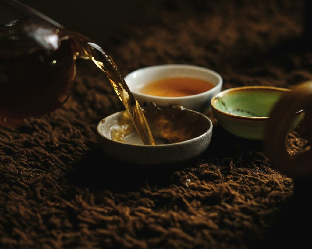 Tea flowing into a ceramic teacup, symbolising a quiet ritual of tea preparation and mindful enjoyment.