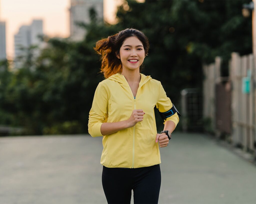A woman running outdoors in sportswear, capturing motion and energy while symbolising fitness, health, and an active lifestyle.