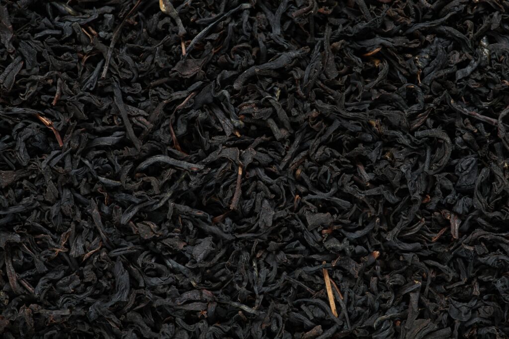 Rich, dark premium black tea leaves presented in detail, known for their bold aroma, deep flavour, and refined character.