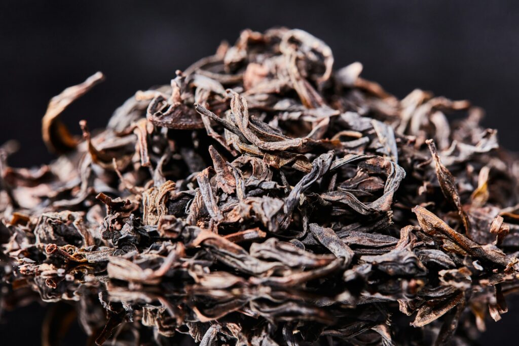 Hand-processed oolong tea leaves with twisted shapes, representing a harmonious balance between green and black tea traditions.