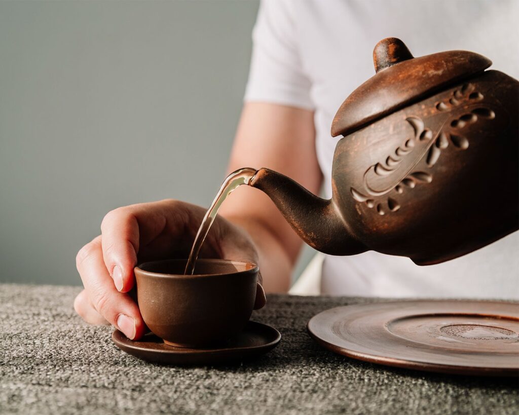 A hand gently holding a warm teacup, capturing a moment of calm and appreciation for freshly brewed tea.