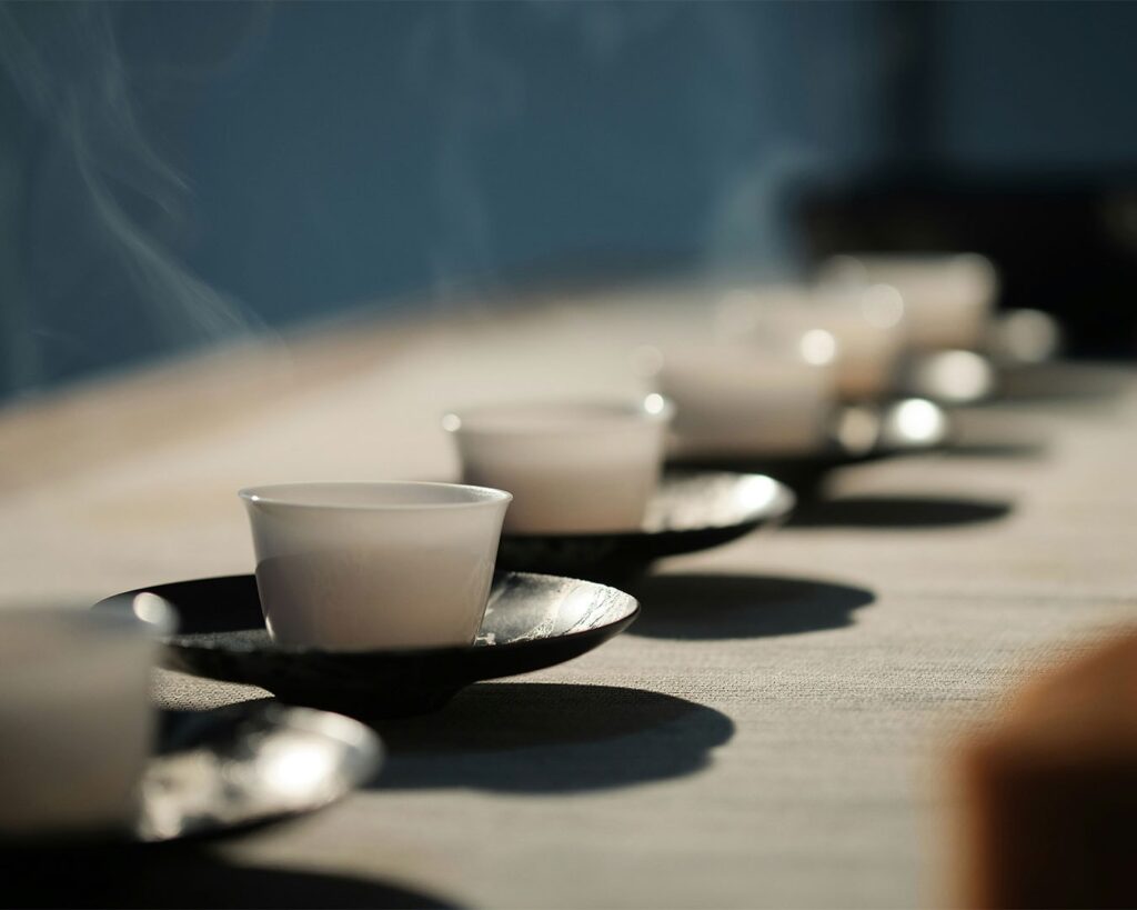 A teacup filled with golden tea, resting on a table, inviting a moment of relaxation and simple elegance.