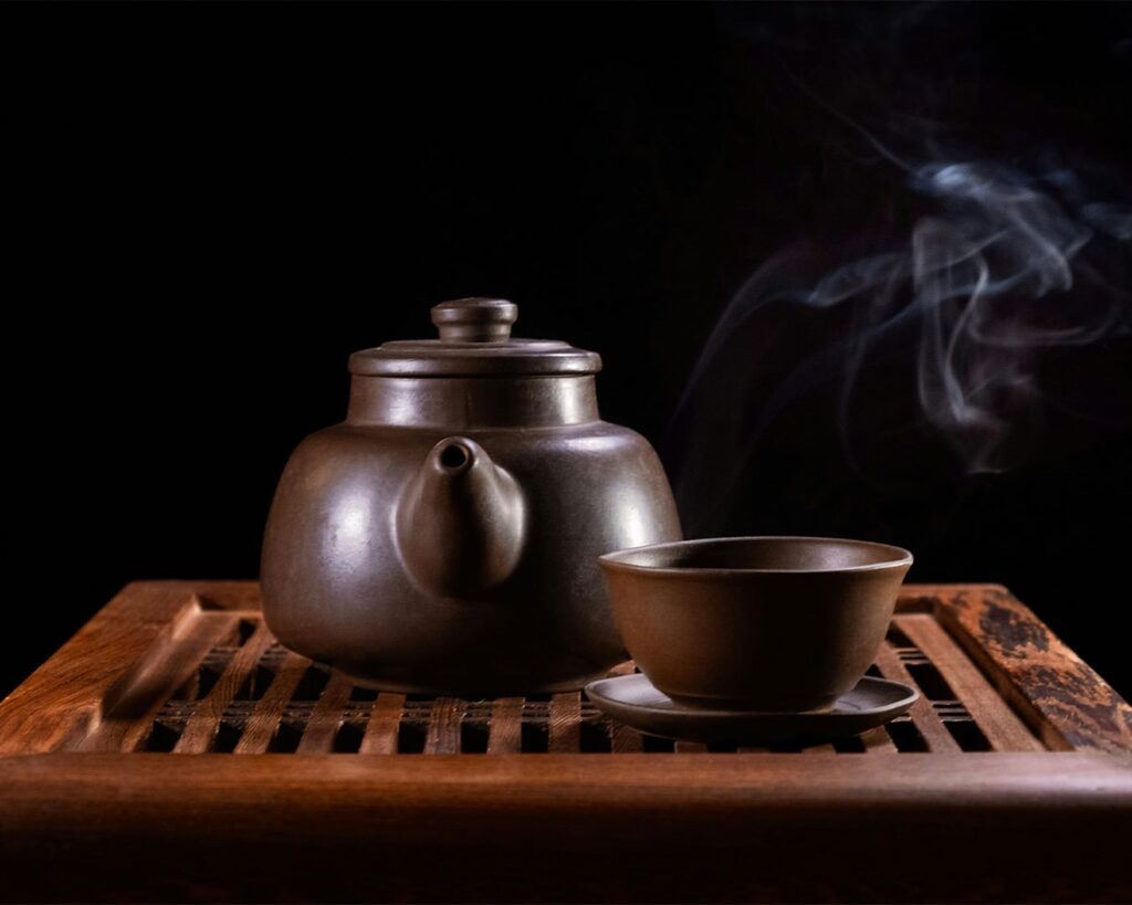 A traditional Chinese teapot accompanied by a delicate teacup, showcasing centuries of refined craftsmanship.