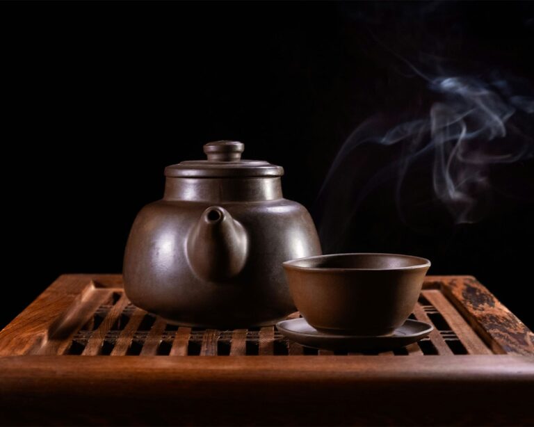 A traditional Chinese teapot accompanied by a delicate teacup, showcasing centuries of refined craftsmanship.