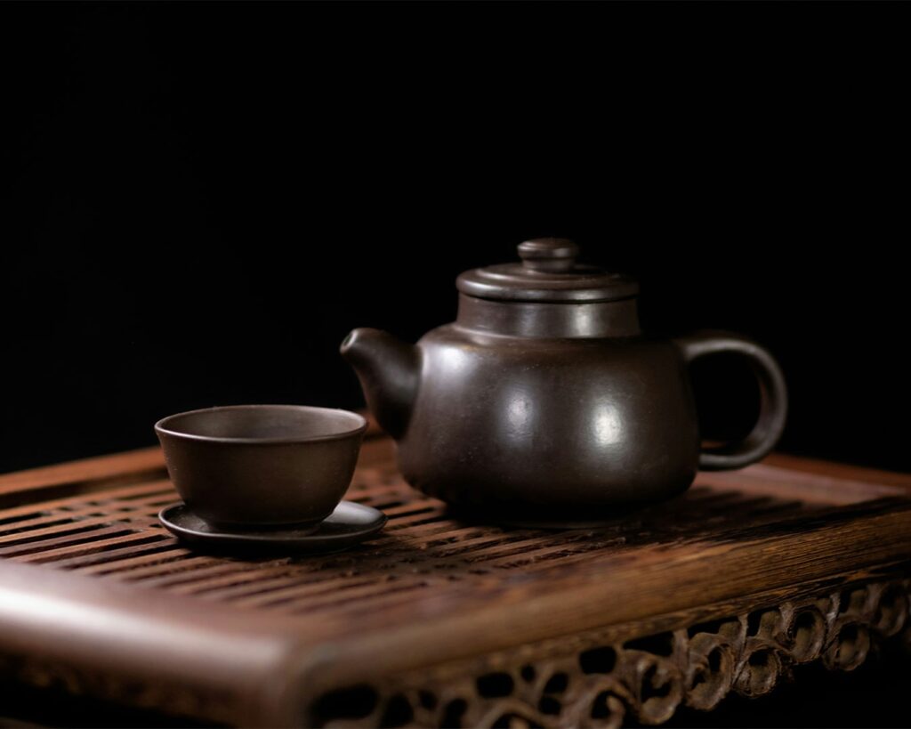 A beautifully arranged Chinese teapot set with matching cups, showcasing refined craftsmanship and a harmonious balance of form and function for traditional tea rituals.
