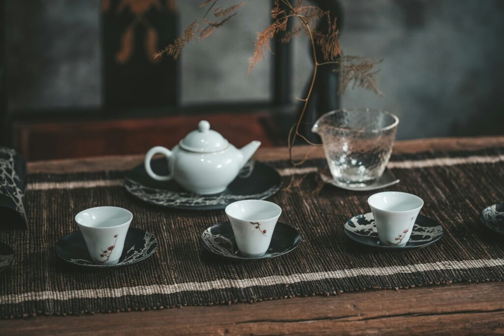An elegant tea cup setting arranged on a wooden table, featuring fine porcelain ware that reflects the calm and refined atmosphere of a traditional premium tea room.