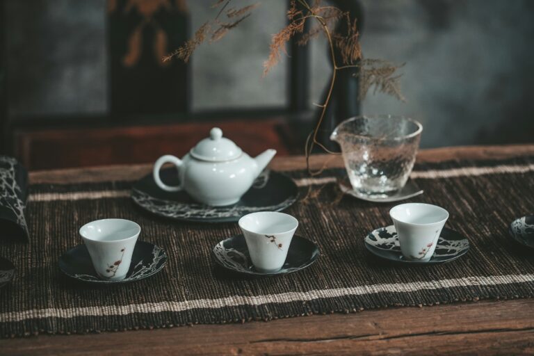 An elegant tea cup setting arranged on a wooden table, featuring fine porcelain ware that reflects the calm and refined atmosphere of a traditional premium tea room.