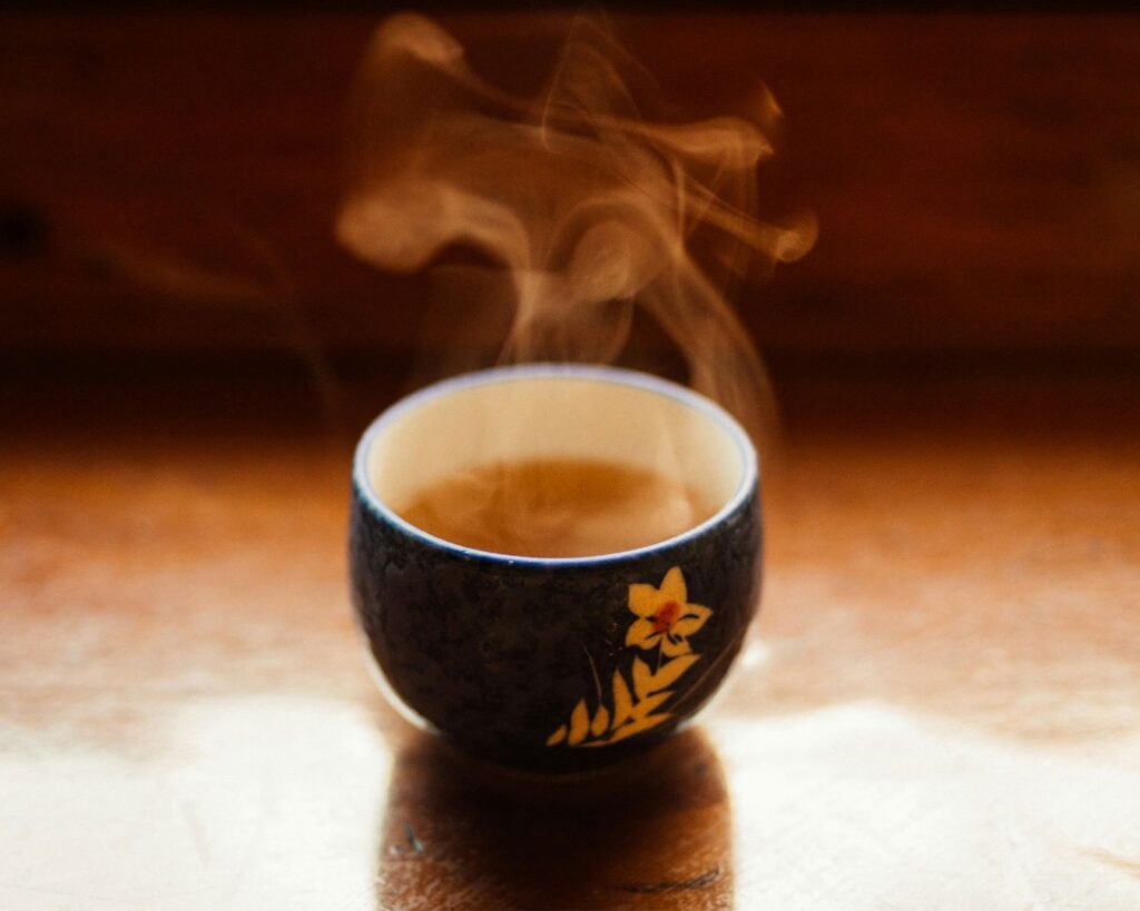 A cup of herbal tea viewed from above, with soft lighting that emphasises its golden-brown tone.