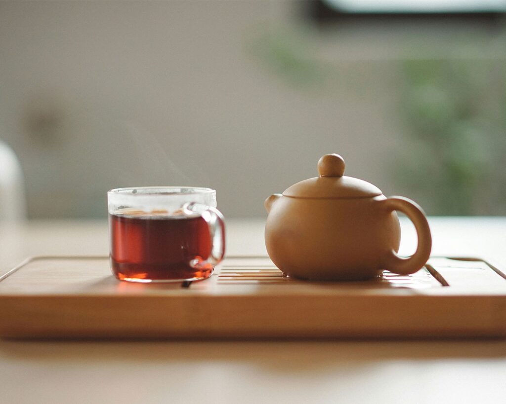 A collection of teacups filled with freshly brewed tea, arranged together to highlight both the colour of the tea and the beauty of the teaware